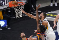 Utah Jazz center Rudy Gobert, above right, dunks as Golden State Warriors' Stephen Curry, left, and James Wiseman (33) defend during the first half of an NBA basketball game Saturday, Jan. 23, 2021, in Salt Lake City. (AP Photo/Rick Bowmer)