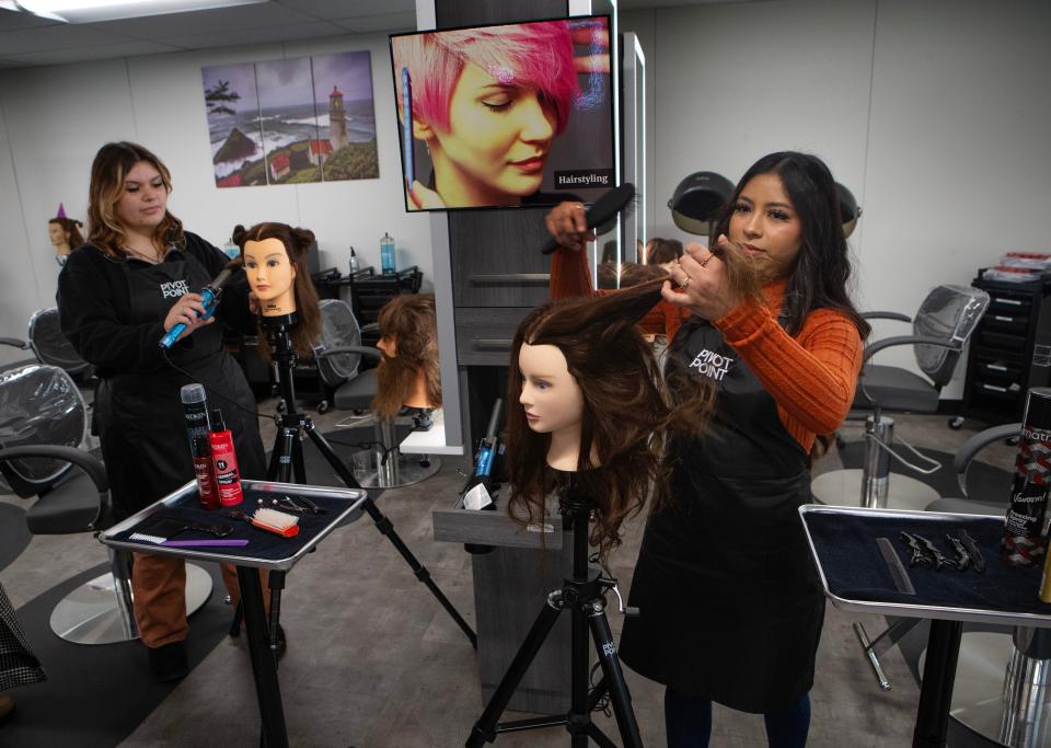 Gateways High School students Danica Bolt, 16, left, and Suly Ramirez, 17, demonstrate some of the techniques they have learned during a Cosmetology Open House in Springfield on Tuesday.