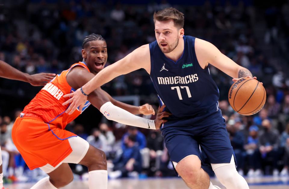 Mavericks guard Luka Doncic (77) drives to the basket past Thunder guard Shai Gilgeous-Alexander during a game at American Airlines Center in Dallas on Jan. 17, 2022.