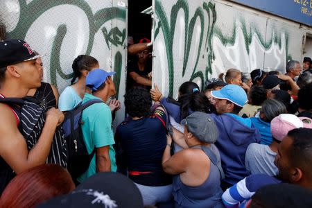 People push a door while they gather to try to buy pasta outside a supermarket in Caracas, Venezuela June 10, 2016. REUTERS/Carlos Garcia Rawlins/File Photo