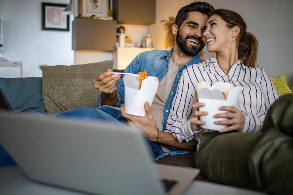 people eating takeout on the couch