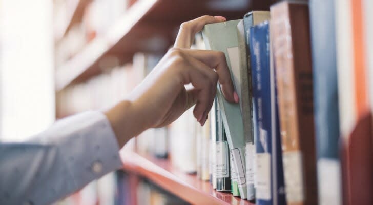 Man taking a book off a shelf