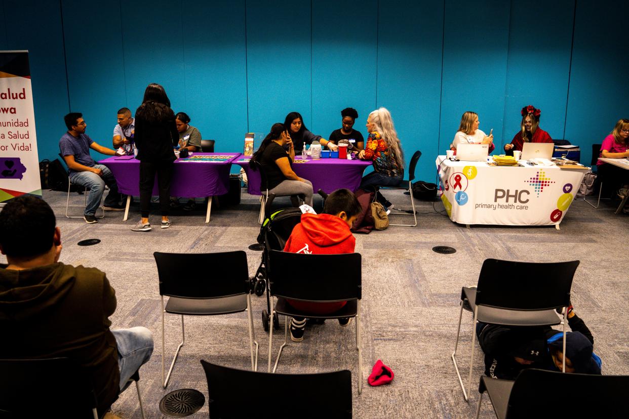 Community members receive blood pressure tests from MiSalud Iowa and updated COVID vaccinations from Primary Health Care during a Day of the Dead celebration organized by Latinx Immigrants of Iowa at the Central Library on Thursday, November 2, 2023 in Des Moines.
