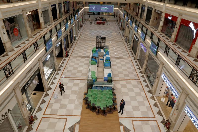 A worker cleans the floor at a mall ahead of its reopening during an extended nationwide lockdown to slow down the spread of the coronavirus disease (COVID-19), in New Delhi