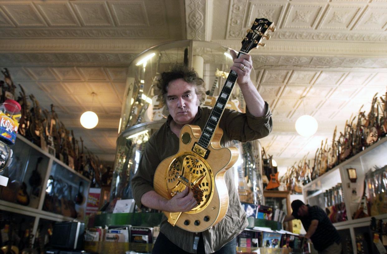 From August 2005: House of Guitars co-owner Armand Schaubroeck holds a Resonator electric blues guitar that he designed.