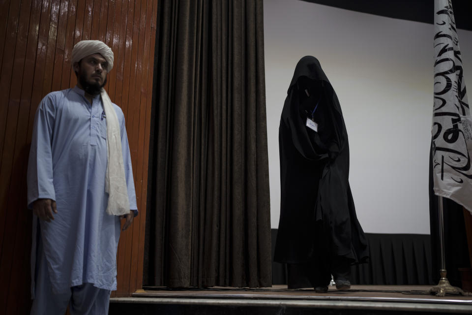 A woman walks down from the stage inside an auditorium at Kabul University's education center during a demonstration in support of the Taliban government in Kabul, Afghanistan, Saturday, Sept. 11, 2021. (AP Photo/Felipe Dana)