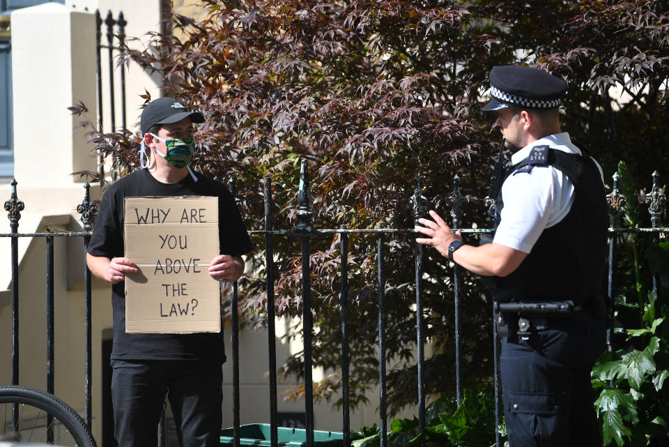 A police officer talks to a protester outside the north London home of Prime Minister Boris Johnson's senior aide Dominic Cummings , as lockdown questions continue to bombard the Government after it emerged that he travelled to his parents' home despite coronavirus-related restrictions. (Photo by Victoria Jones/PA Images via Getty Images)