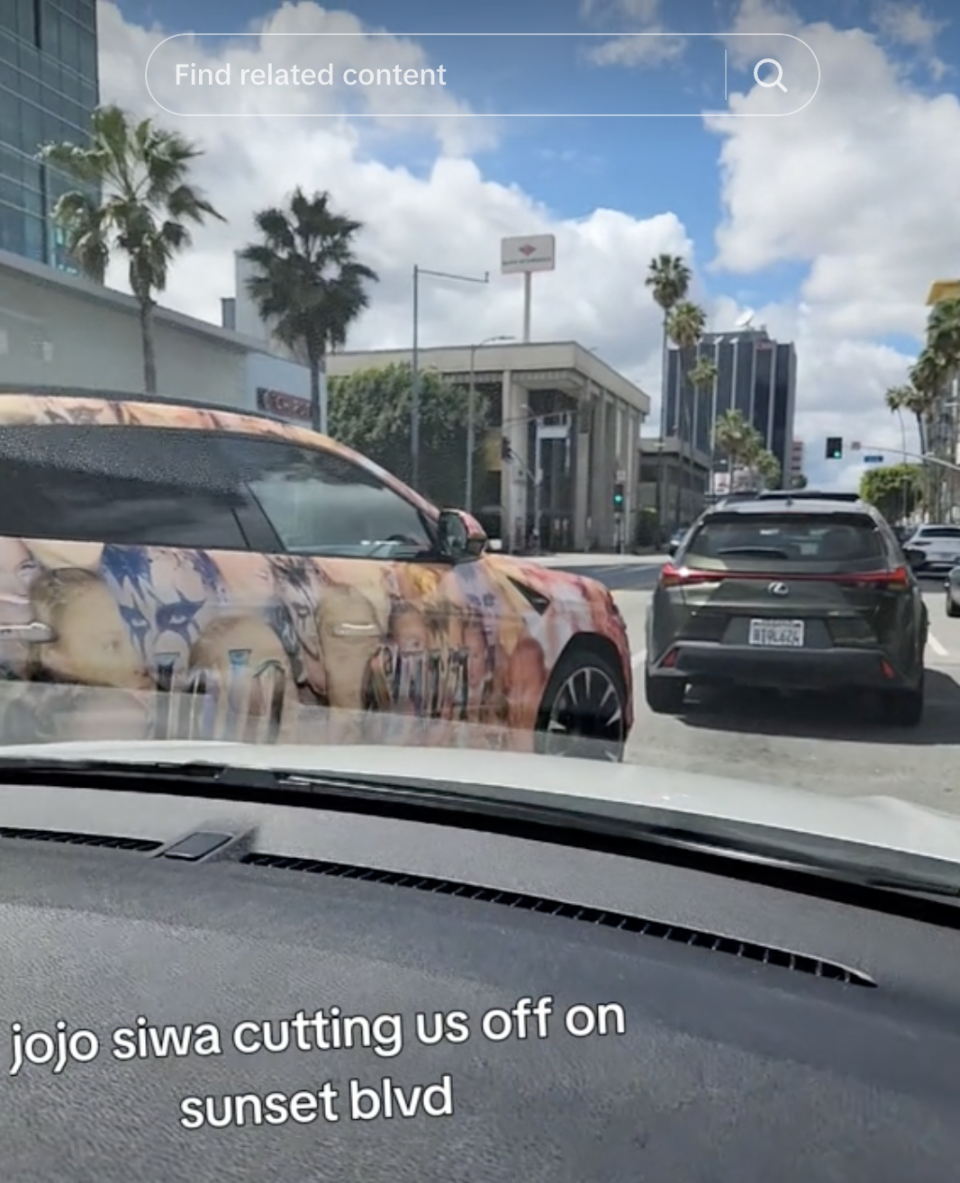 Car with custom wrap, cut off by Jojo Siwa's car, view from inside another vehicle on Sunset Blvd