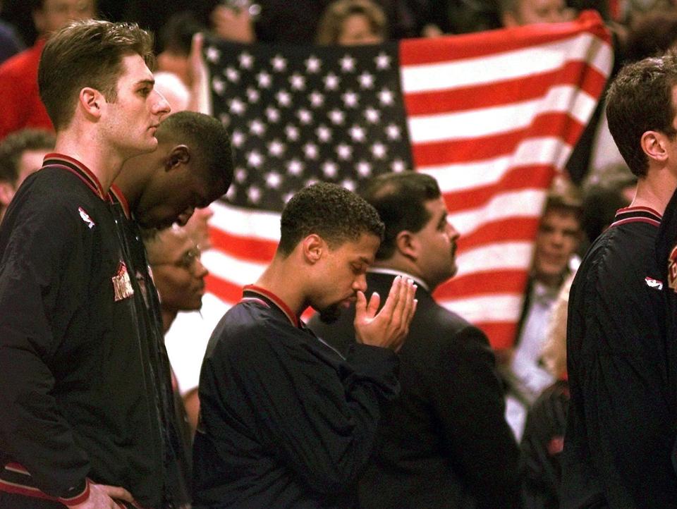 FILE - In this March 15, 1996, file photo, Denver Nuggets guard Mahmoud Abdul-Rauf stands with his teammates and prays during the national anthem before an NBA basketball game against the Chicago Bulls in Chicago. This was Abdul-Rauf's first game back since he was suspended by the NBA on March 12, 1996, for refusing to participate in the national anthem pre-game ceremony. The anthem is played before the start of every U.S. major sporting event, where fans and players are expected to salute the flag by placing a hand over the heart while singing along. Not doing so is considered unpatriotic by some. The anthem has also been used by athletes as a way to protest. (AP Photo/M. Spencer Green, File)