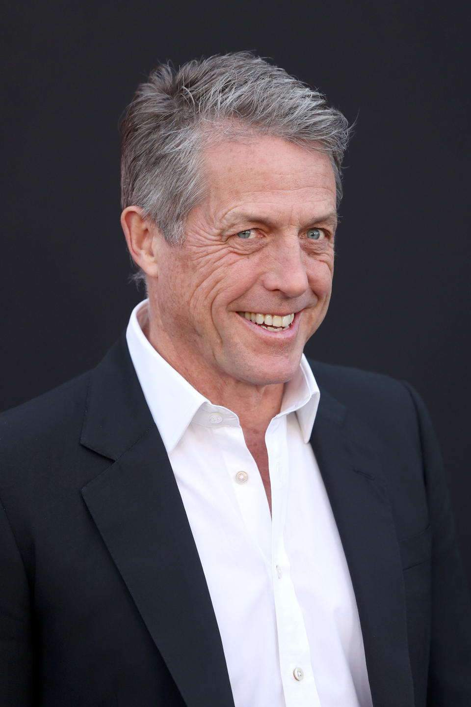 Hugh Grant smiling at a film premiere