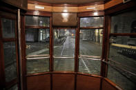 An empty street is seen from a tram streetcar window, in Milan, northern Italy, early Sunday, Oct. 25, 2020. Since the 11 p.m.-5 a.m. curfew took effect last Thursday, people can only move around during those hours for reasons of work, health or necessity. (AP Photo/Luca Bruno)