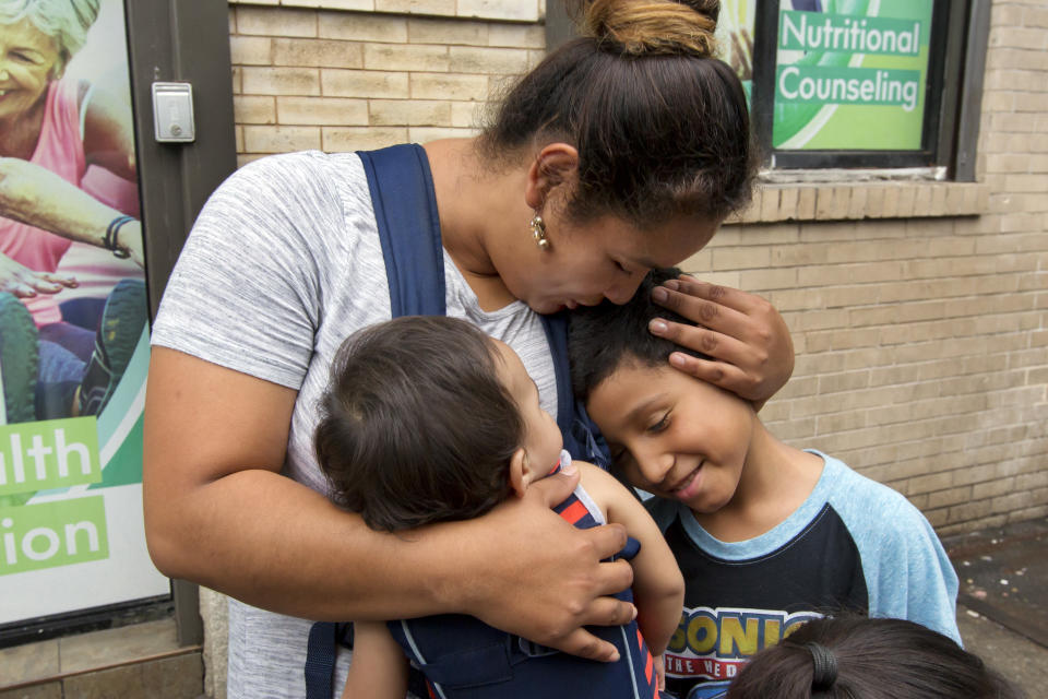 FILE - In this Friday, Aug. 3, 2018 file photo, Honduran Eilyn Carbajal hugs her then-8-year-old son Nahun Eduardo Puerto Pineda, right, after they were reunited at the Cayuga Center, in New York. Fearful immigrant families hoping to reunite with children and teenagers who crossed the border alone are facing an intimidating system that includes submitting fingerprints by all adults in the household where a migrant child will live. Under new rules, the finger prints are shared with Immigration and Customs Enforcement. (AP Photo/Richard Drew)