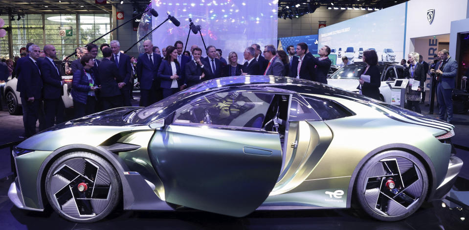 French President Emmanuel Macron views the Peugeot DS E-Tense Performance at the Paris Car Show, Monday, Oct. 17, 2022. Europe is leading the charge into electric vehicles as battery powered cars break out of their niche market of first adopters and enter the mainstream with increasing market share that's forecast to grow strongly as the EU pushes to phase out internal combustion engine vehicles by 2035 (Gonzalo Fuentes/Pool via AP)