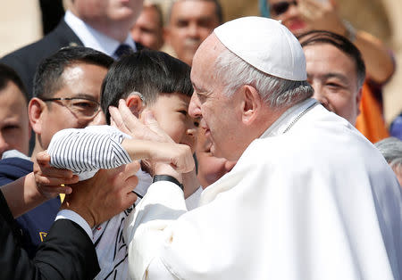 Pope Francis greets a child from China, at the end of the weekly general audience in the Vatican, May 22, 2019. REUTERS/Remo Casilli