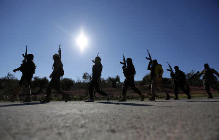 Turkish-backed Free Syrian Army fighters walk together after advancing north of Afrin, Syria March 17, 2018. REUTERS/Khalil Ashawi