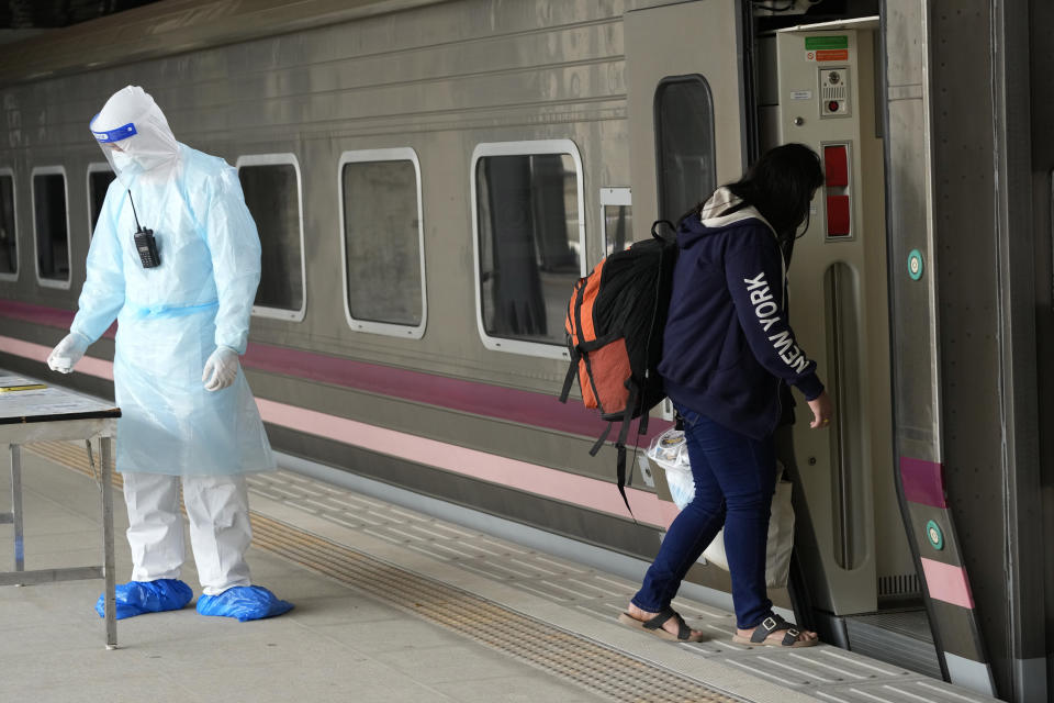 A COVID-19 patient gets into a train at Rangsit train station in Pathum Thani Province, Thailand to head to her hometown Tuesday, July 27, 2021. Thai authorities began transporting some people who have tested positive with the coronavirus from Bangkok to their hometowns on Tuesday for isolation and treatment, to alleviate the burden on the capital’s overwhelmed medical system. (AP Photo/Sakchai Lalit)