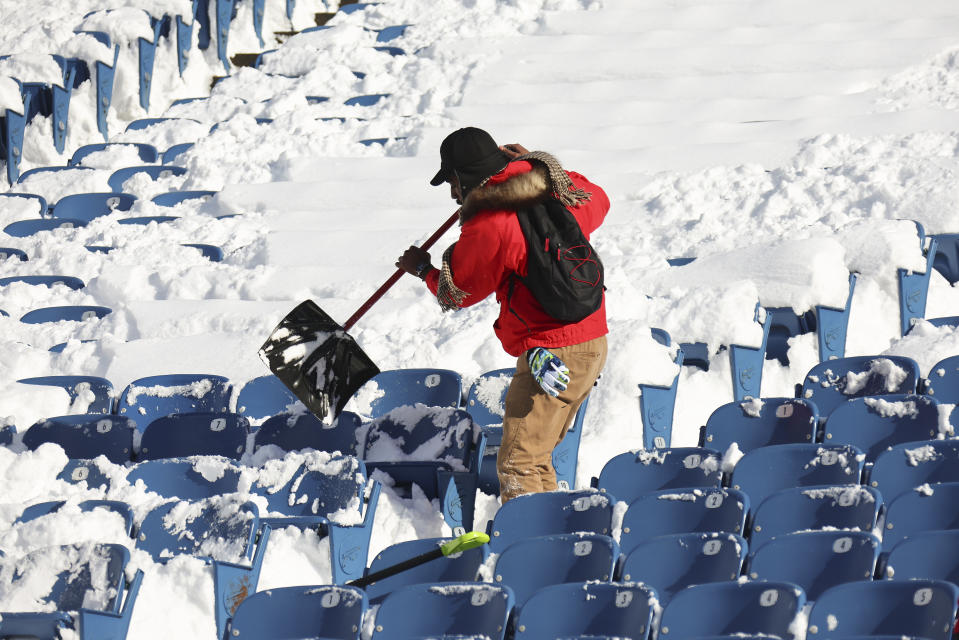 A stadium worker clears snow from seats before an NFL wild-card playoff football game between the Buffalo Bills and the Pittsburgh Steelers, Monday, Jan. 15, 2024, in Buffalo, N.Y. (AP Photo/Jeffrey T. Barnes)