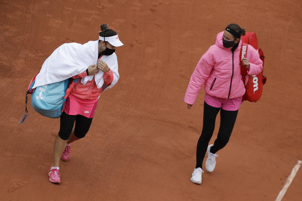 Victoria Azarenka of Belarus, right, and Montenegro's Danka Kovinic walk onto the court to resume the first round match of the French Open tennis tournament against at the Roland Garros stadium in Paris, France, Sunday, Sept. 27, 2020. (AP Photo/Alessandra Tarantino)