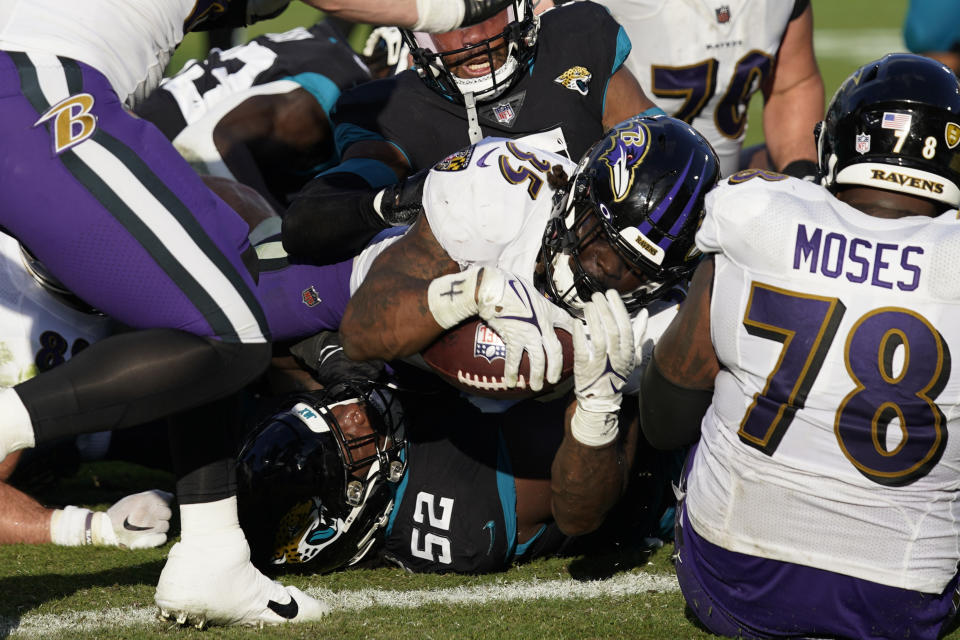 Baltimore Ravens running back Gus Edwards (35) scores a touchdown against Jacksonville Jaguars defensive tackle DaVon Hamilton (52) during the second half of an NFL football game, Sunday, Nov. 27, 2022, in Jacksonville, Fla. (AP Photo/John Raoux)