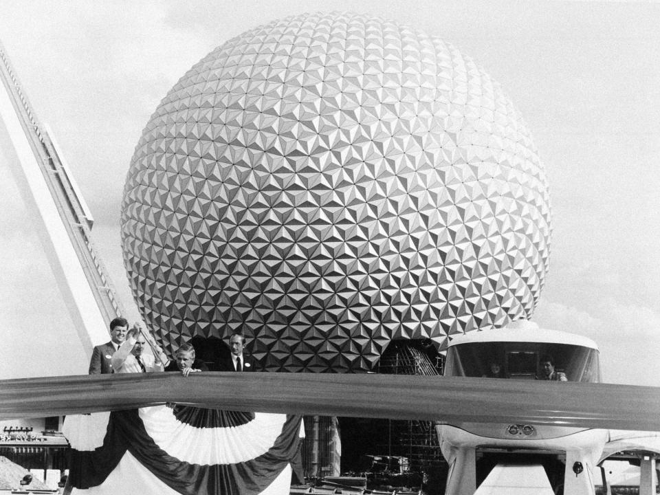 Black and white photo of large Epcot ball structure and large ribbon in front of it.
