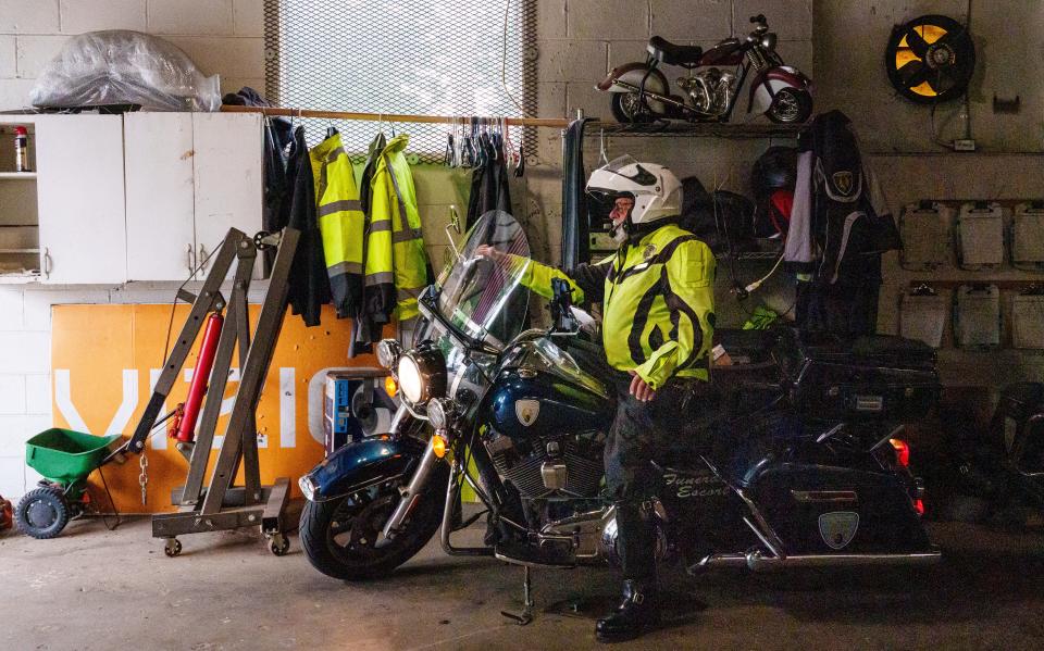 David Craig checks the lights Thursday, June 29, 2023, on one of Gary Harriman's multiple motorcycles inside his south side garage.