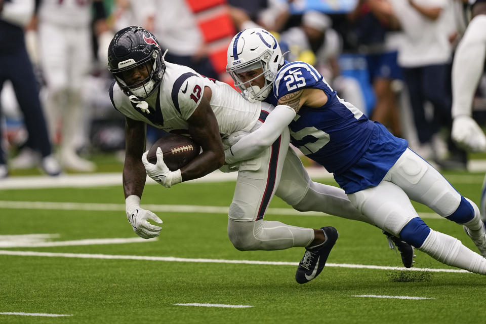 Houston Texans wide receiver Nico Collins (12) is tackled by Indianapolis Colts safety Rodney Thomas II (25) after picking up a first down in the second half of an NFL football game in Houston, Sunday, Sept. 17, 2023. (AP Photo/David J. Phillip)