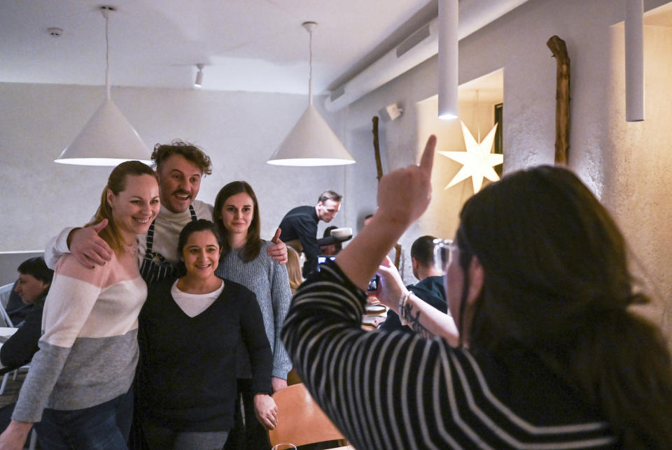 Ukrainian chef Ievgen Klopotenko poses with customers at his restaurant 100 Rokiv Tomu Vpered (100 Years Ago Ahead) in Kyiv, Ukraine, Sunday, Feb. 5, 2023. Klopotenko has been outspoken during the Russian invasion in promoting national dishes, especially borsch, as a way of establishing a definite identity for Ukraine. (AP Photo/Chris Warde-Jones)