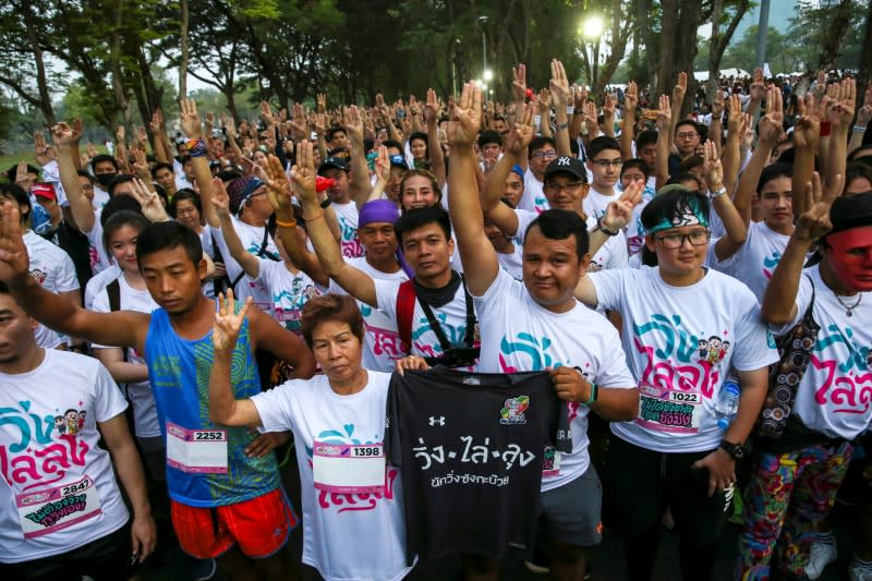 Runners flash three finger salute as they attend at "Run Against Dictatorship" event at a Public park in Bangkok