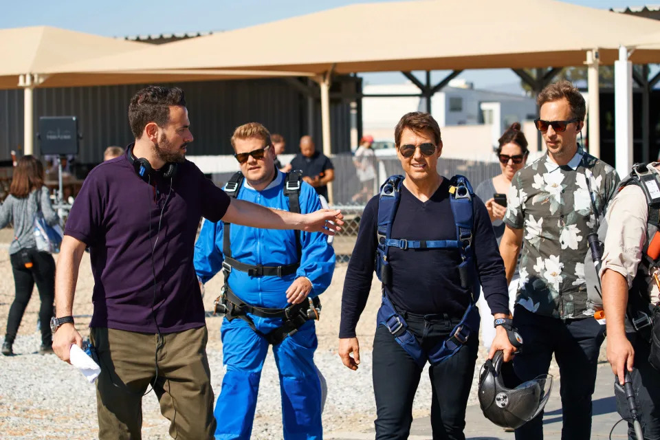 Tom Cruise and James Corden discuss with skydiving instructors, including Ben Winston, as they prepare for a skydive adventure