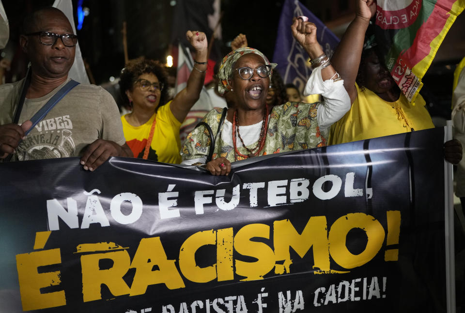 Gente sostiene la pancarta con la leyenda "No es fútbol, es racismo" en portugués durante una protesta en Río de Janeiro por los insultos racistas contra Vinicus Júnior en la liga española, el jueves 25 de mayo del 2023. (AP Foto/Silvia Izquierdo)