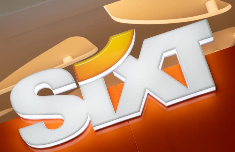 The logo of car rental company Sixt during a photo shoot for the German Press Agency at a rental station at Munich Airport. German car rental company Sixt has announced plans to buy as many as 250,000 vehicles from carmaker Stellantis over the next three years for the company's rental fleets in Europe and North America. Peter Kneffel/dpa