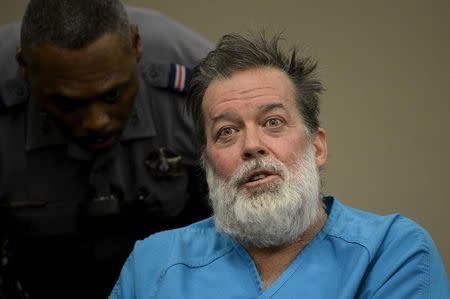 A deputy tries to calm Robert Lewis Dear, 57, accused of shooting three people to death and wounding nine others at a Planned Parenthood clinic in Colorado last month, as he spoke out at his hearing to face 179 counts of various criminal charges at an El Paso County court in Colorado Springs, Colorado December 9, 2015. REUTERS/Andy Cross/Pool