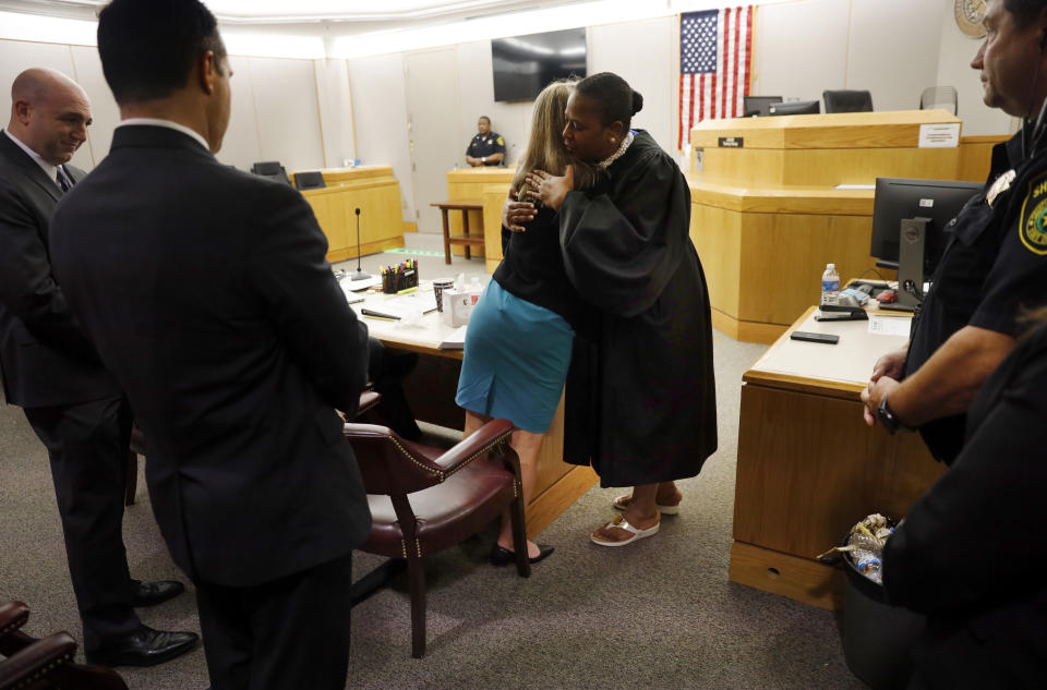 Former Dallas Police Officer Amber Guyger gives State District Judge Tammy Kemp a hug after the judge had given her a Bible and before Guyger left for jail, Wednesday, Oct. 2, 2019, in Dallas. Guyger, who said she mistook neighbor Botham Jean's apartment for her own and fatally shot him in his living room, was sentenced to a decade in prison. (Tom Fox/The Dallas Morning News via AP, Pool)