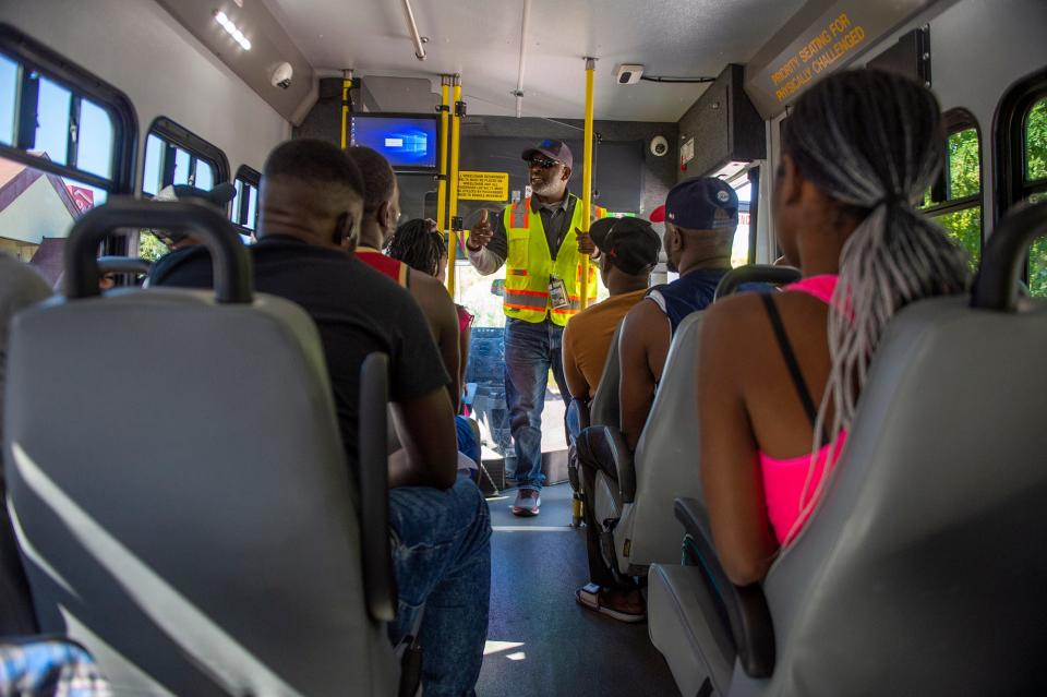 Giovanni Fleurancois, general manager for National Express at the Metrowest Regional Transit Authority, instructs Haitian asylum seekers living in Framingham how to use the bus system, Aug. 31, 2023.