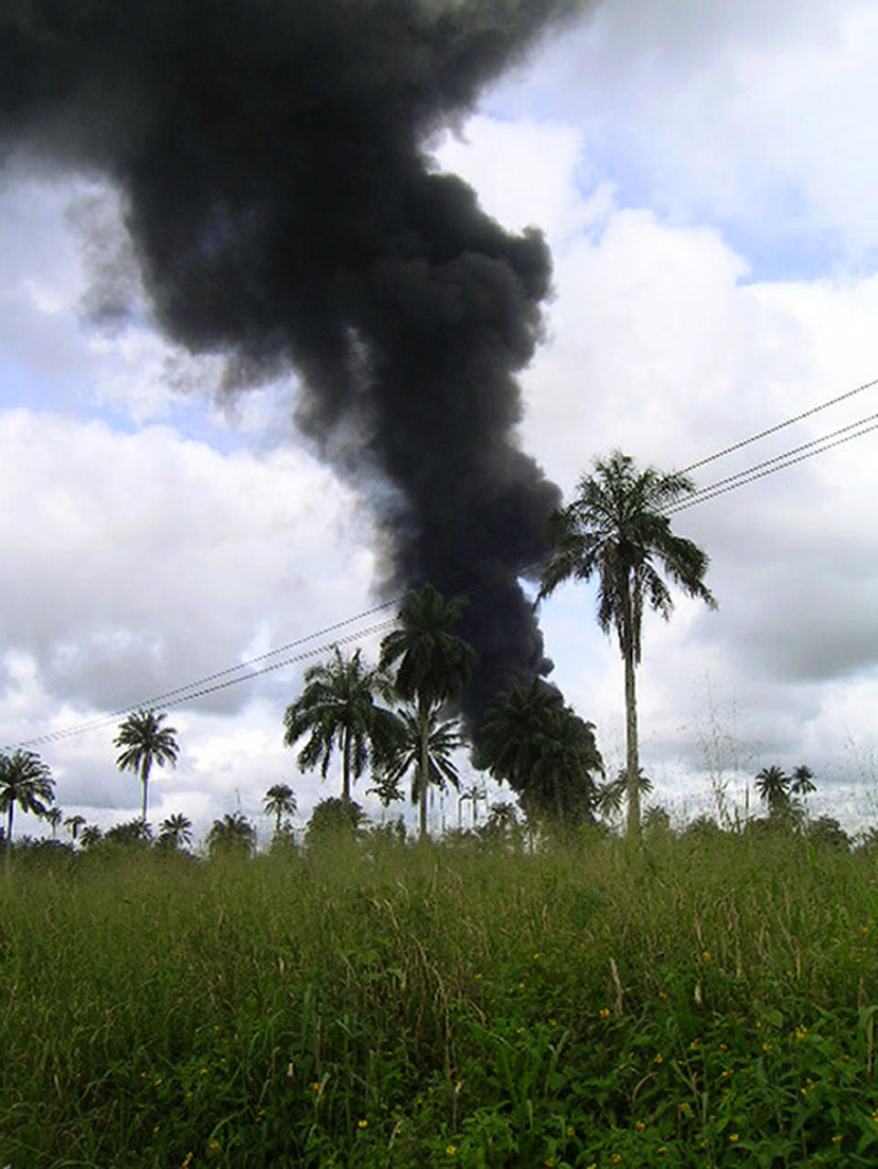 FILE - In this file photo dated Tuesday, Oct. 12, 2004, smoke rises from an oil pipeline fire near the village of Goi in Nigeria. A Dutch appeals court Friday Feb. 12, 2021, has ordered energy giant Shell’s Nigerian subsidiary to compensate farmers in two villages including Goi for damage to their land caused by a pair of oil leaks more than 15 years ago. (AP Photo)