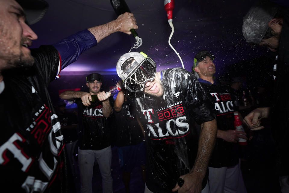 Texas Rangers' Nathan Eovaldi celebrates with teammates after winning an American League Division Series baseball game against the Baltimore Orioles in Arlington, Texas, Tuesday, Oct. 10, 2023. (AP Photo/Julio Cortez)