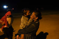 A migrant child from Honduras kisses her mother through masks at an intake area after they turned themselves in upon crossing the U.S.-Mexico border, late Tuesday, May 11, 2021, in La Joya, Texas. The U.S. government continues to report large numbers of migrants crossing the U.S.-Mexico border with an increase in adult crossers. But families and unaccompanied children are still arriving in dramatic numbers despite the weather changing in the Rio Grande Valley registering hotter days and nights. (AP Photo/Gregory Bull)