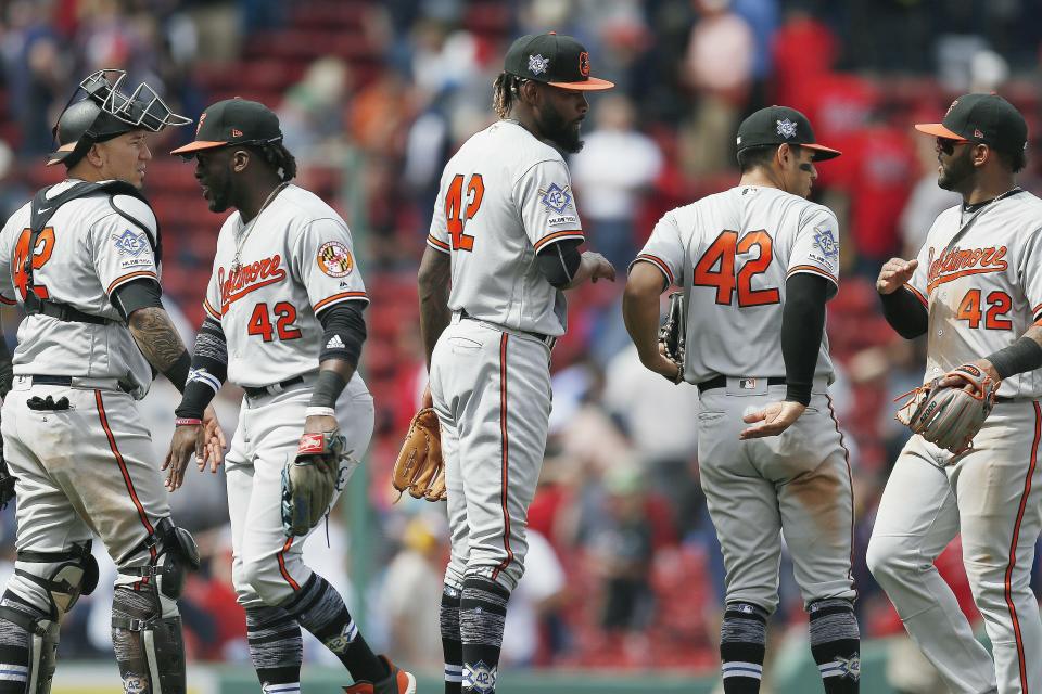 Baltimore Orioles' Miguel Castro, center, and Jesus Sucre, left, celebrate with teammates after defeating the Boston Red Sox during a baseball game in Boston, Monday, April 15, 2019. The players are all wearing (42) in honor of Jackie Robinson Day.(AP Photo/Michael Dwyer)