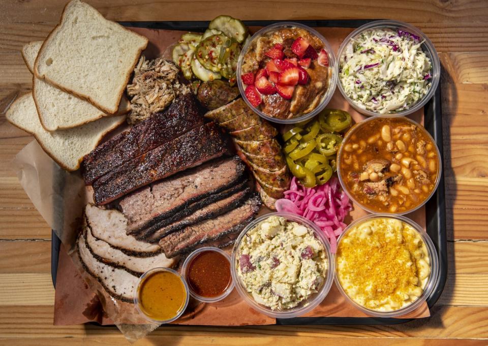 An overhead photo of a barbecue tray from Moo's Craft Barbecue featuring brisket, sausage, mac and cheese, and potato salad.