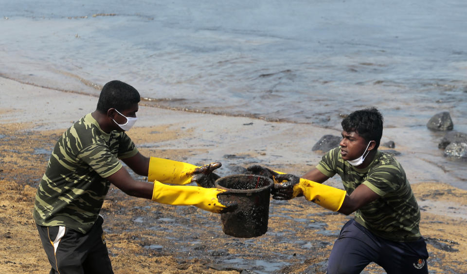 Sri Lankan army soldiers remove oil slick and sand from a beach following an oil spill in Uswetakeiyawa, a coastal town north of Colombo, Sri Lanka, Monday, Sept. 10, 2019.Sri Lanka deployed hundreds of coast guard and navy personnel on Monday to clean oil slicks on a coastal stretch near the capital following a spill caused by a pipeline leak. (AP Photo/Eranga Jayawardena)