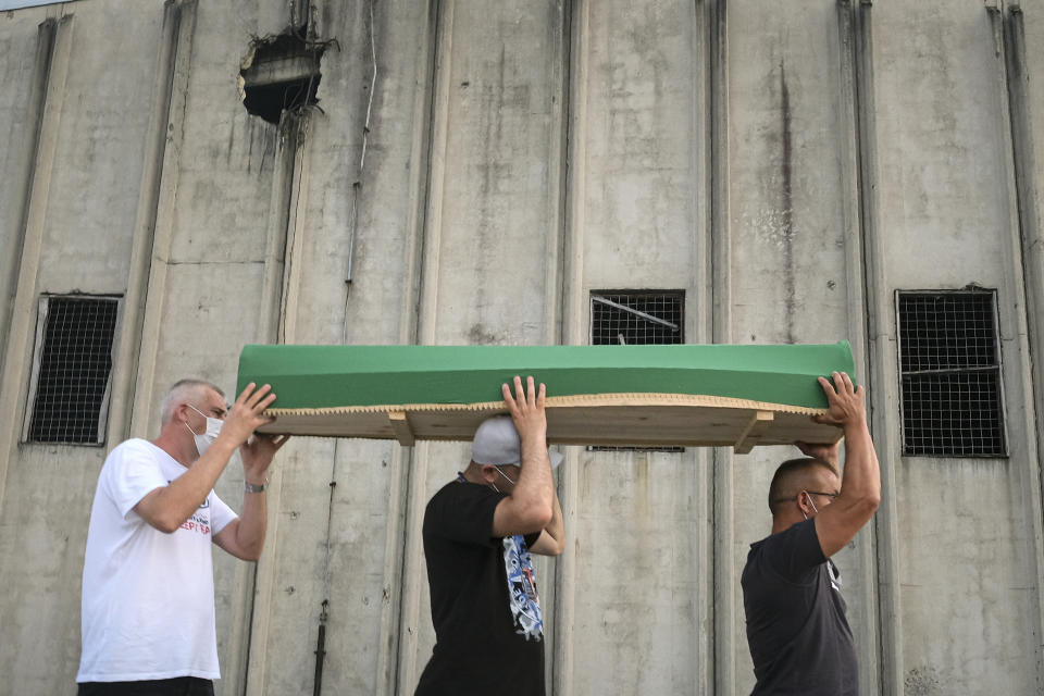 Bosnians carry the coffin of a victim outside the former UN base in Potocari, near Srebrenica, Bosnia, Friday, July 10, 2020. Nine newly found and identified men and boys will be laid to rest when Bosnians commemorate on Saturday 25 years since more than 8,000 Bosnian Muslims perished in 10 days of slaughter, after Srebrenica was overrun by Bosnian Serb forces during the closing months of the country's 1992-95 fratricidal war, in Europe's worst post-WWII massacre. (AP Photo/Kemal Softic)