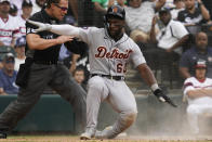 Detroit Tigers' Akil Baddoo, right, reacts after scoring on a wild pitch by Chicago White Sox starting pitcher Lance Lynn during the third inning of a baseball game in Chicago, Sunday, Aug. 14, 2022. (AP Photo/Nam Y. Huh)