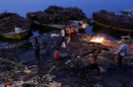 People watch as pyres burn at a cremation ground on the banks of the Ganges River in Varanasi, India April 7, 2017. REUTERS/Danish Siddiqui