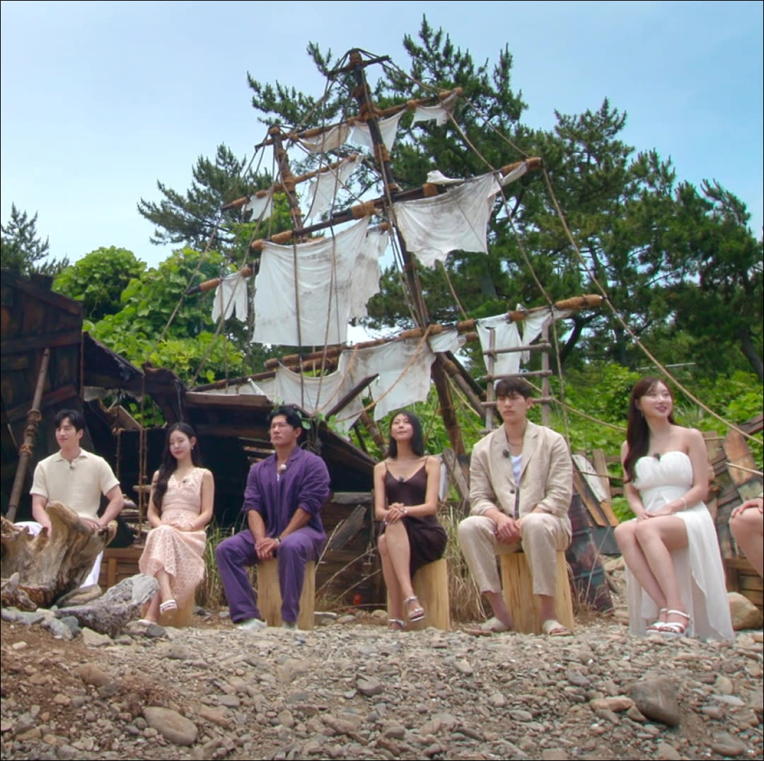  Cast members sit in front of a beached ship on single's inferno season 3. 