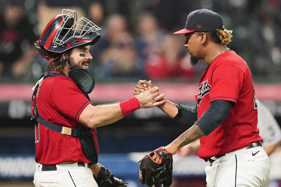 Cleveland Indians relief pitcher Emmanuel Clase, right, and catcher Austin Hedges celebrate after the Indians defeated the Kansas City Royals 4-1 in a baseball game, Tuesday, Sept. 21, 2021, in Cleveland. (AP Photo/Tony Dejak)