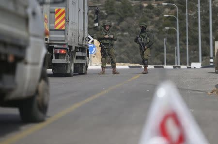 Israeli soldiers stand guard as they carry out an identity check on Palestinians at an Israeli checkpoint leading to the West Bank city of Ramallah February 1, 2016. REUTERS/Mohamad Torokman
