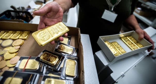 An employee returns a box of one kilogram gold bars to the safe from Swiss manufacturer Argor Hebaeus SA, in this arranged photograph at the Hungarian bullion dealers AranyPiac in Budapest, Hungary, on Monday, June 17, 2013. Hedge funds cut wagers on a gold rally for the first time in three weeks on mounting speculation central banks will curb record stimulus and as this year's slump in bullion spurred losses for billionaire John Paulson. Photographer: Akos Stiller/Bloomberg via Getty Images
