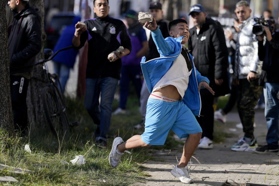 A demonstrator throws a rock at the police during a protest against the death of 11-year-old girl Morena Dominguez, who died from her injuries after criminals tried to rob her, outside a police station on the outskirts of Buenos Aires, Argentina, Wednesday, Aug. 9, 2023. (AP Photo/Natacha Pisarenko)