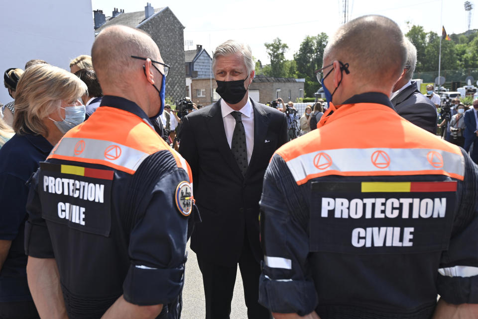 Belgium's King Philippe, center, speaks with members of the Civil Protection Unit prior to participating in a ceremony of one minute of silence to pay respect to victims of the recent floods in Belgium, in Verviers, Belgium, Tuesday, July 20, 2021. Belgium is holding a day of mourning on Tuesday to show respect to the victims of the devastating flooding last week, when massive rains turned streets in eastern Europe into deadly torrents of water, mud and flotsam. (Eric Lalmand, Pool Photo via AP)