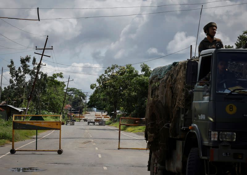 A security force trooper rides a vehicle on a highway at Torbung village